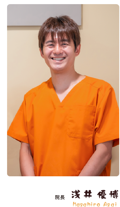 オレンジ色の制服を着た、ひなたぼっこ鍼灸・整骨院の院長の笑顔の写真。