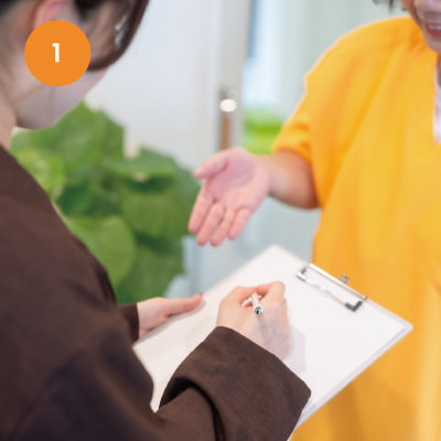 受付で問診票を記入している患者の様子。予約優先制でスムーズに案内。