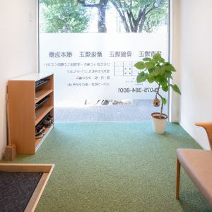 明るい陽射しが差し込む待合スペース。落ち着いた雰囲気のソファと観葉植物。