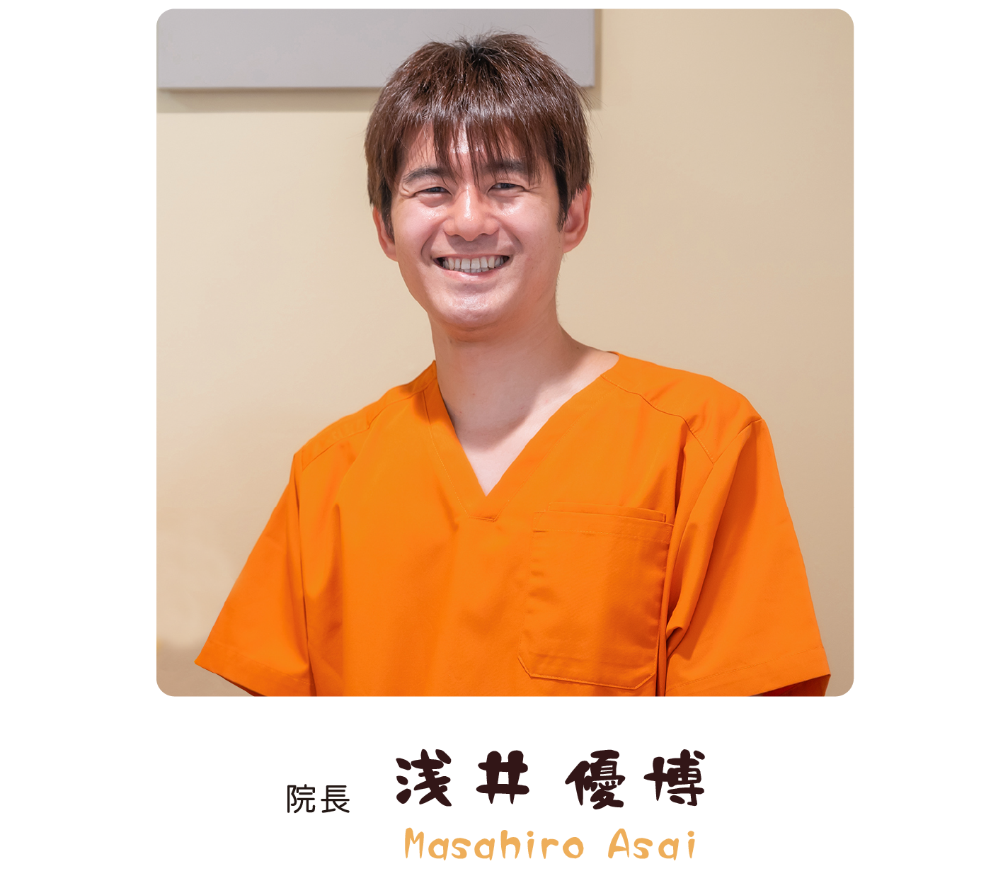 オレンジ色の制服を着た、ひなたぼっこ鍼灸・整骨院の院長の笑顔の写真。