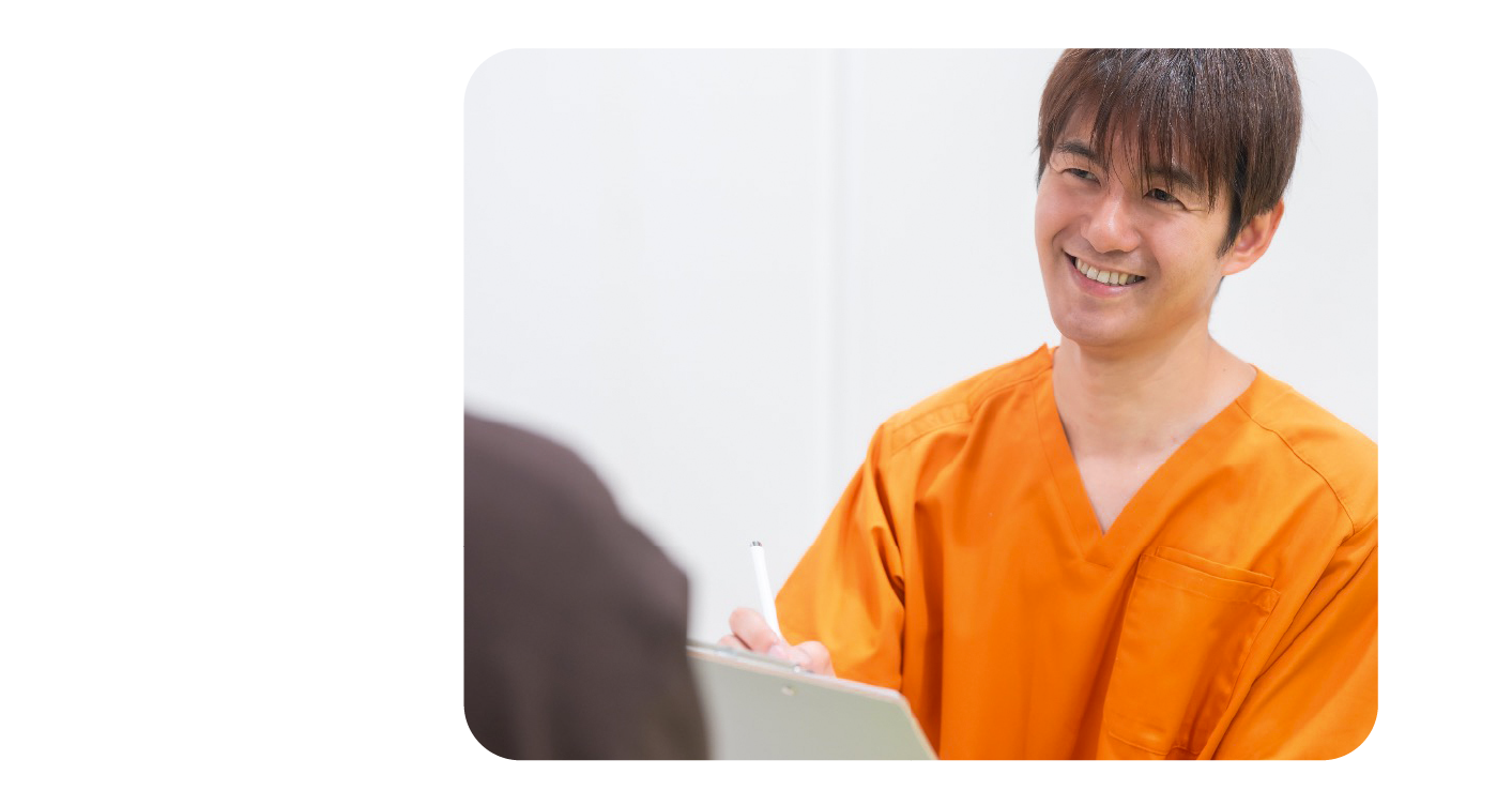 スタッフが笑顔で患者の悩みを丁寧にヒアリングしている様子。