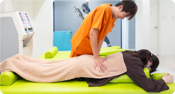 患者の腰を優しく施術している様子。国家資格者が丁寧に対応。